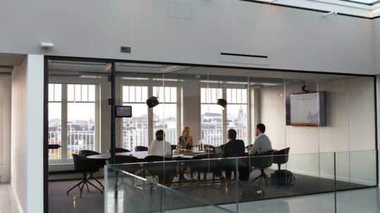 Colleagues discussing documents in a meeting room