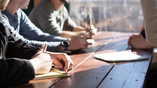 People discussing documents around a meeting table